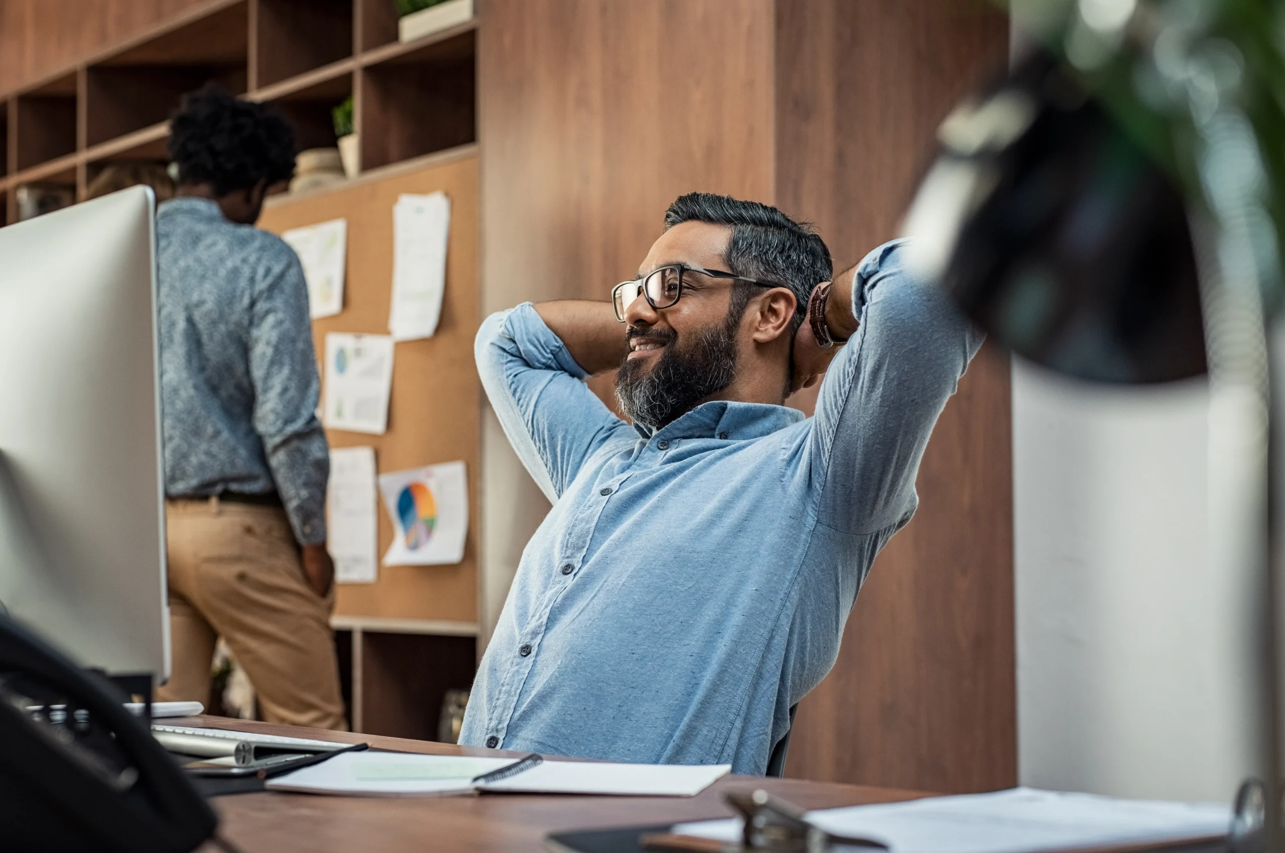 Office worker stretching at desk to relieve back pain and improve posture