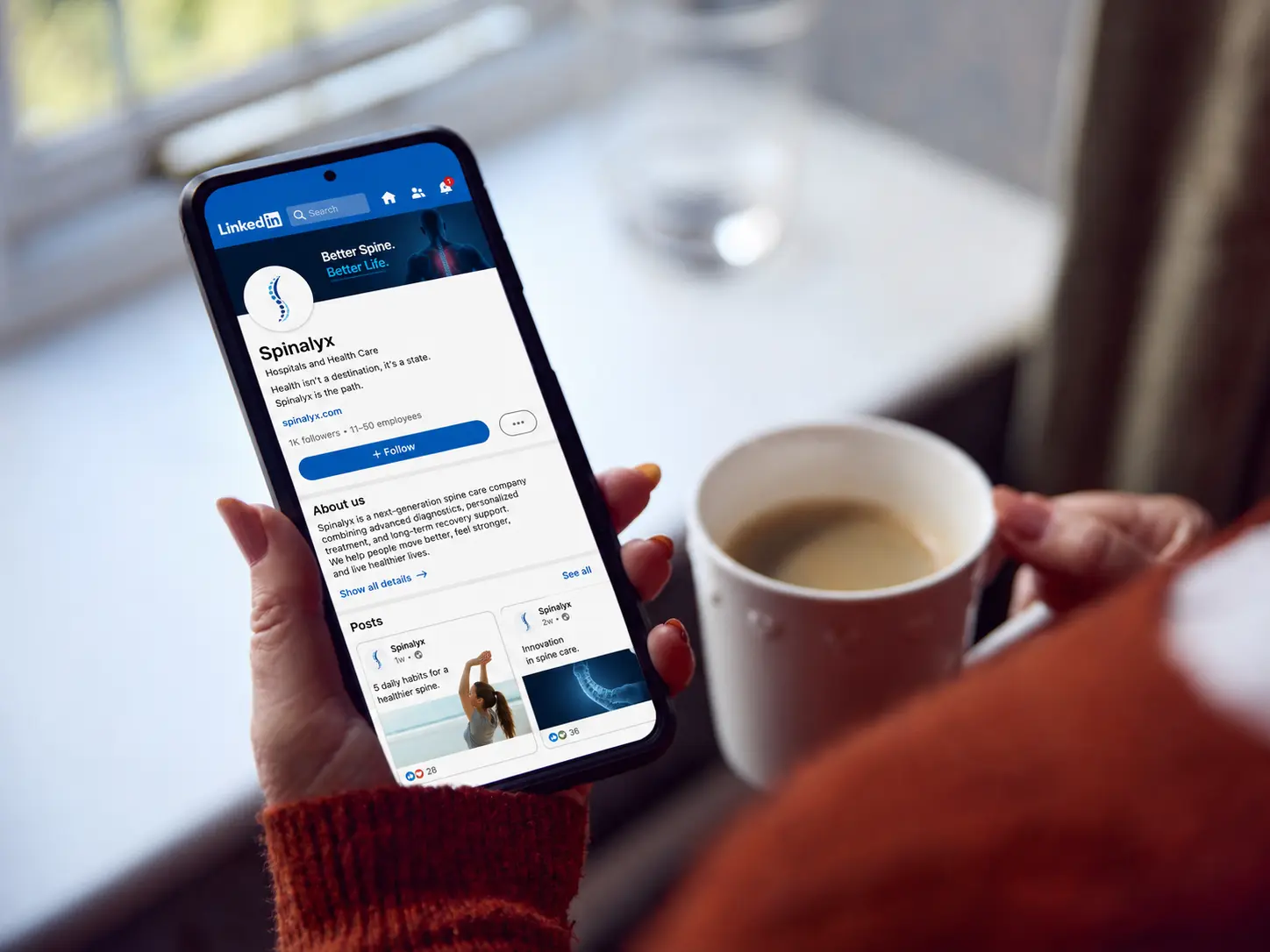 Spinalyx LinkedIn profile shown on a smartphone, highlighting spine care, recovery support, and health innovation.